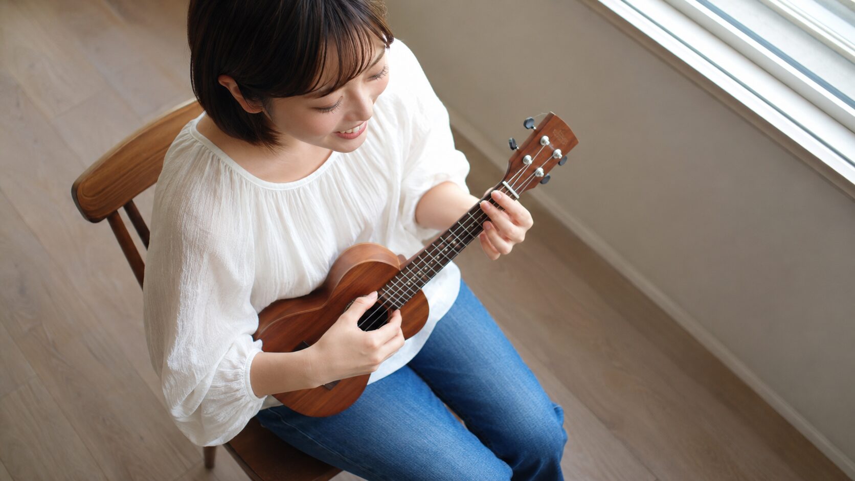 ウクレレの音階と覚え方を楽しむ女性が指板を見つめる様子